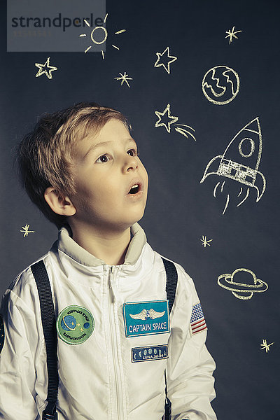 Porträt eines Jungen mit Raumanzug  umkreist von Himmelskörpern und Koryphäen