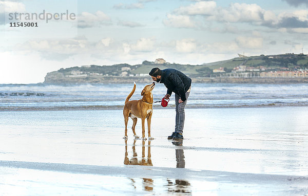 Spanien  Gijon  Mann mit seinem Hund am Strand