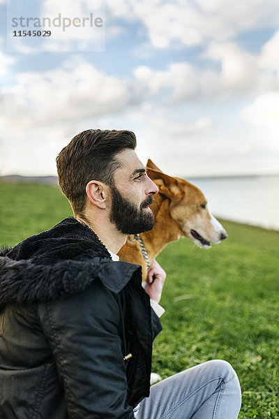 Der Mensch und sein Hund auf einer Wiese