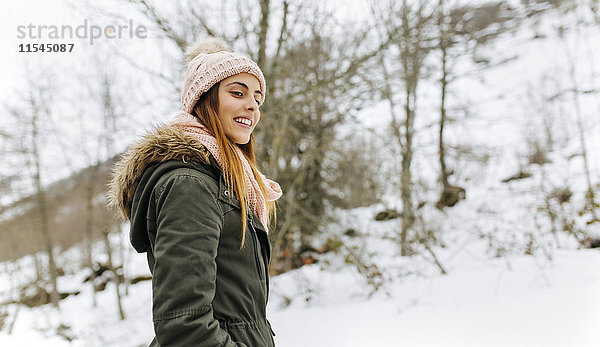Spanien  Asturien  glückliche junge Frau in den verschneiten Bergen