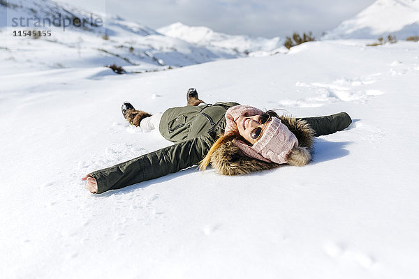 Spanien  Asturien  verspielte Frau im Schnee liegend