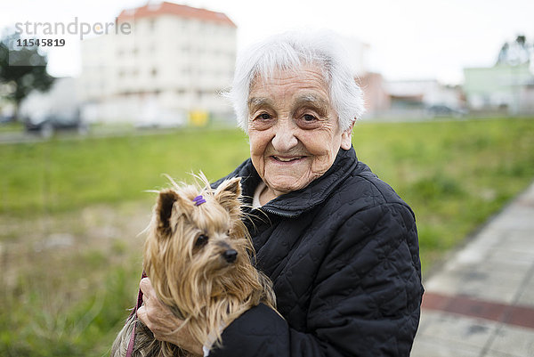 Porträt einer älteren Frau mit Yorkshire Terrier auf den Armen