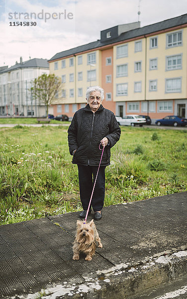 Seniorin geht mit ihrem Yorkshire Terrier spazieren.