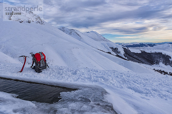 Italien  Umbrien  Monti Sibillini Nationalpark  Sonnenuntergang am Berg Redentore im Winter  Eispickel und Rucksack