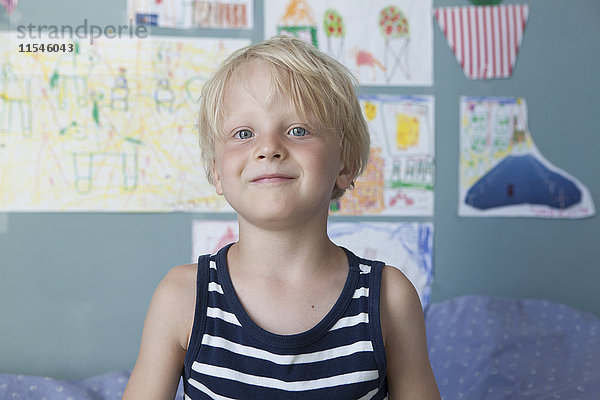Porträt des selbstbewussten kleinen blonden Jungen im Kinderzimmer