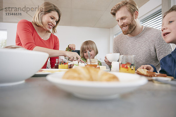 Glückliche vierköpfige Familie beim Frühstücken