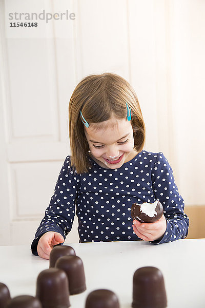 Kleines Mädchen isst Schoko-Marshmallow
