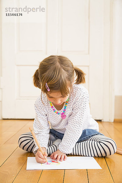 Kleines Mädchen sitzend auf Holzbodenmalerei mit Buntstift