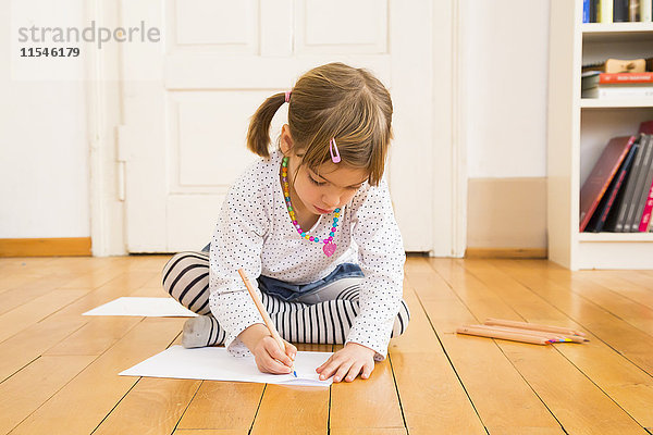 Kleines Mädchen sitzend auf Holzbodenmalerei mit Buntstift