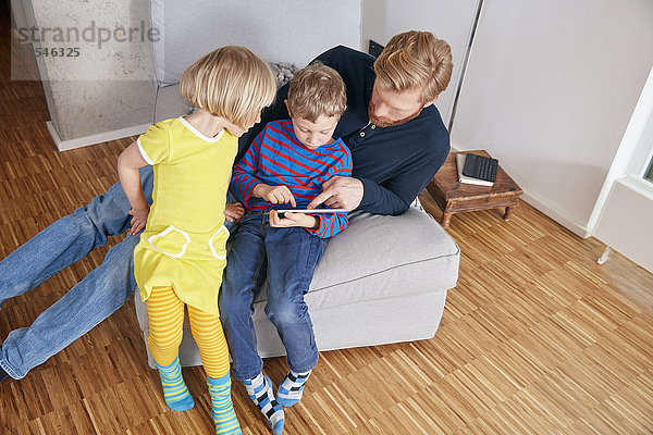 Vater und zwei Kinder mit digitalem Tablett