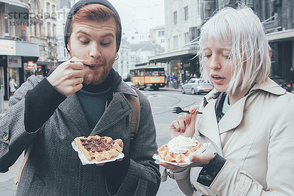 Belgien  Antwerpen  junges Paar beim Essen von belgischen Waffeln auf der Straße