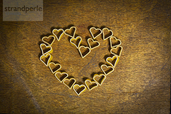 Herzförmige Nudeln als Herz auf Holz