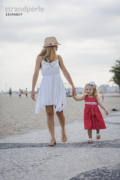Brasilien  Rio de Janeiro  Mutter und Tochter beim Spaziergang am Strand von Copacabana