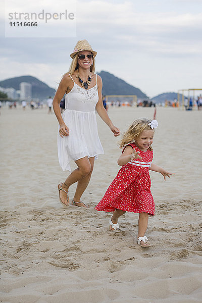 Brasilien  Rio de Janeiro  glückliche Mutter und Tochter am Strand von Copacabana