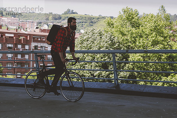 Spanien  Bilbao  Mann mit Rennrad auf einer Brücke