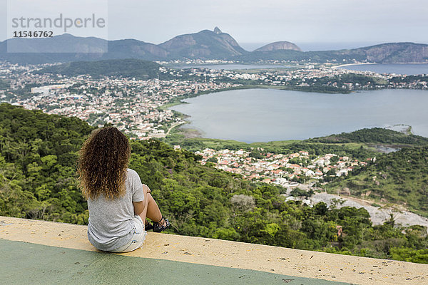 Brasilien  Frau sitzt auf einem Aussichtspunkt in Rio de Janeiro