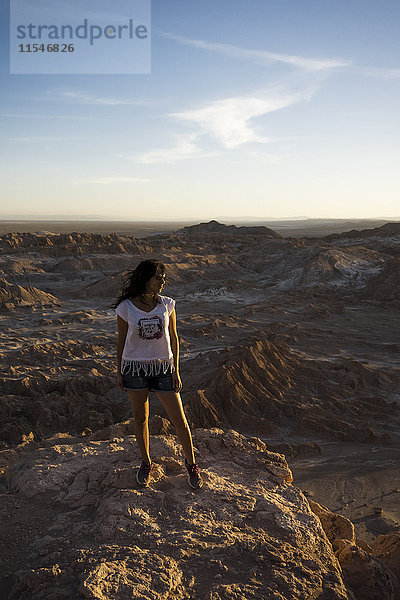 Chile  San Pedro de Atacama  Frau auf einem Felsen in der Atacama-Wüste stehend