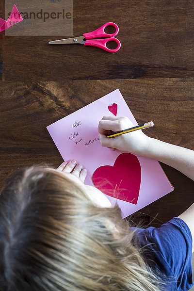 Mädchen schreiben auf Muttertagskarte