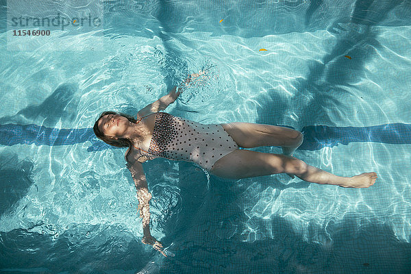 Frau schwimmt auf dem Wasser eines Schwimmbades