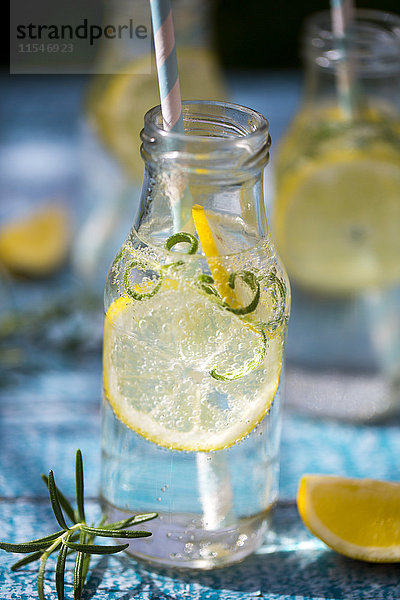 Scheibe Zitrone und Rosmarin in Wasserflasche  Trinkhalm
