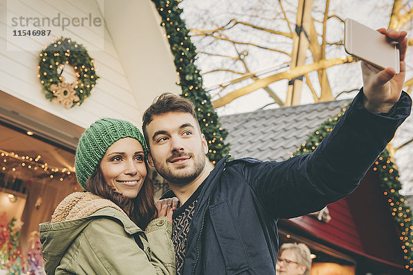 Ein Paar nimmt einen Selfie auf dem Weihnachtsmarkt mit.