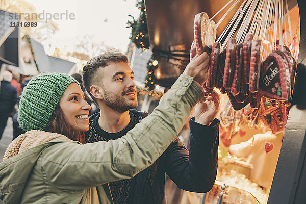 Paar schaut sich Lebkuchenherzen auf dem Weihnachtsmarkt an