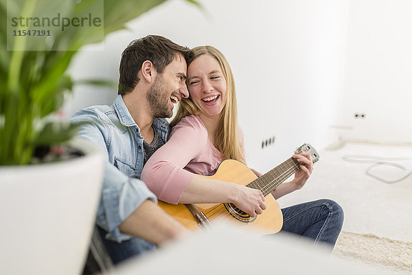 Glückliches Paar beim Gitarrespielen und Singen