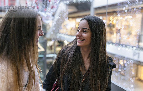 Zwei Freundinnen von Angesicht zu Angesicht in einem Einkaufszentrum