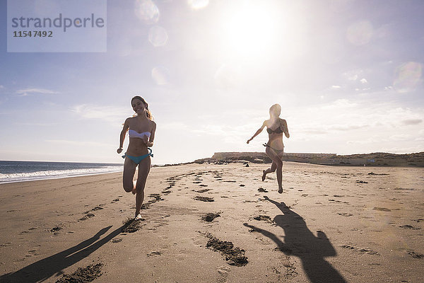 Spanien  Teneriffa  zwei Freundinnen  die am Strand rennen