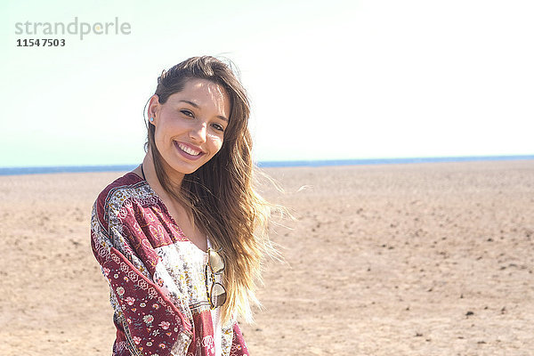Spanien  Teneriffa  Portrait einer lächelnden jungen Frau am Strand