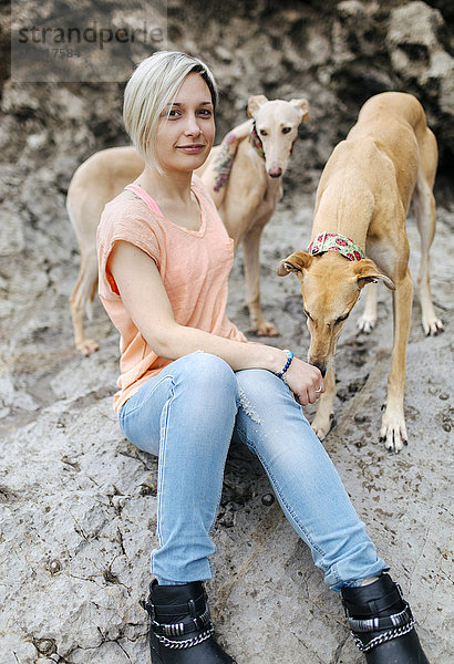 Spanien  Llanes  Portrait einer jungen Frau mit ihren Windhunden am Strand