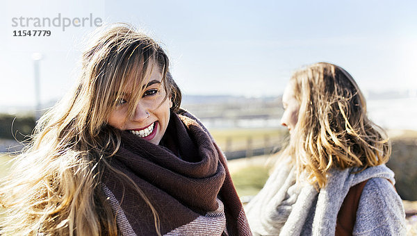 Porträt einer glücklichen jungen Frau mit Freund im Freien