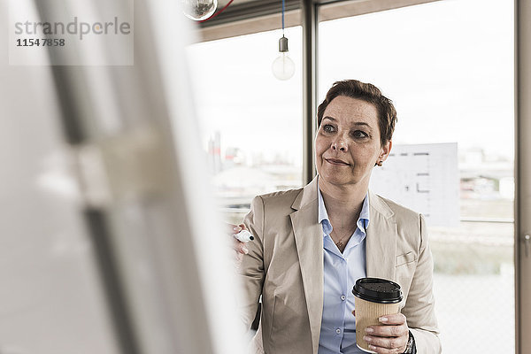 Geschäftsfrau beim Blick auf Flipchart