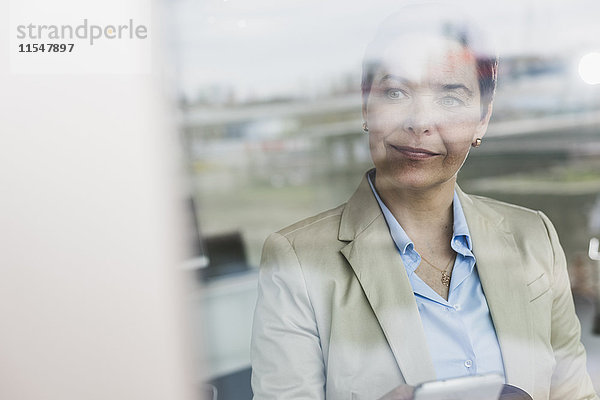 Geschäftsfrau hinter der Fensterscheibe