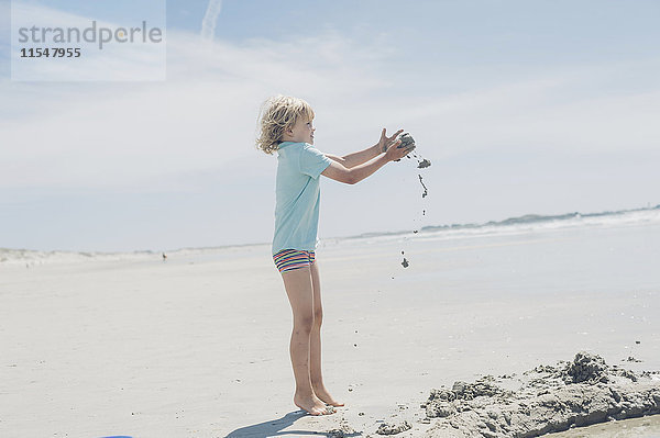 Frankreich  Bretagne  Finistere  Pointe de la Torche  Junge spielt mit Sand am Strand