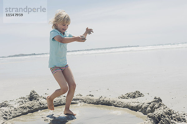 Frankreich  Bretagne  Finistere  Pointe de la Torche  Junge spielt mit Sand am Strand