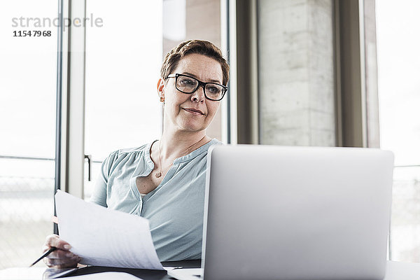 Geschäftsfrau beim Blick auf Laptop im Büro