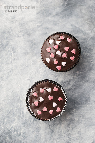 Cupcake mit Schokoladenglasur und Zuckerherzen