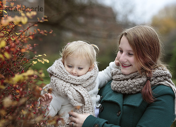 Junge Frau und ihre kleine Tochter im Herbst