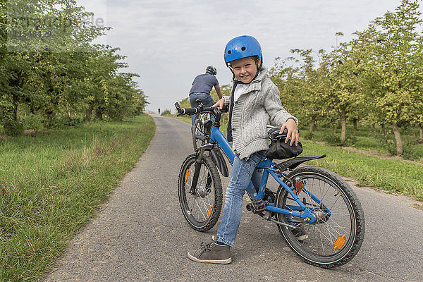 Portrait des kleinen Jungen auf Fahrradtour mit seinem Vater