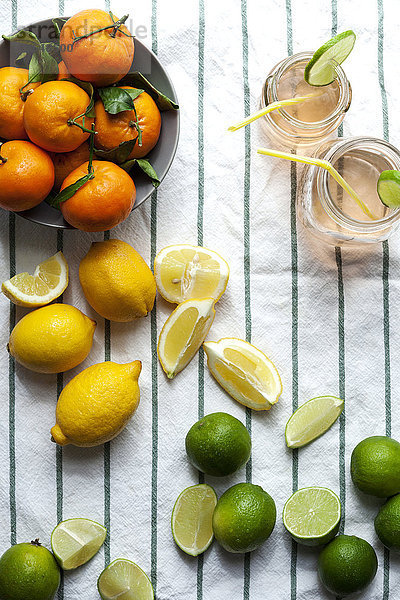 Zwei Gläser Limonade und verschiedene Zitrusfrüchte