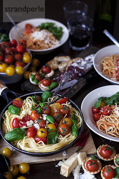 Zubereitete Spaghetti mit Tomaten  Basilikumblättern und Parmesan