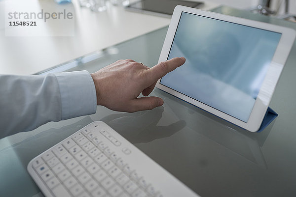 Mann zeigt auf digitales Tablett im Büro