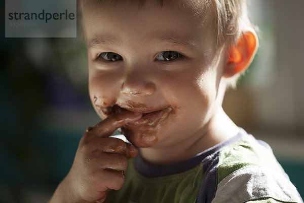 Lächelnder kleiner Junge beim Schokoladenessen