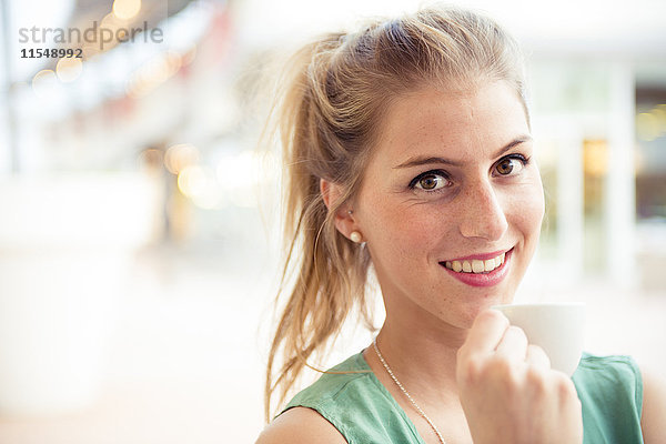 Porträt einer lächelnden blonden Frau im Outdoor-Café