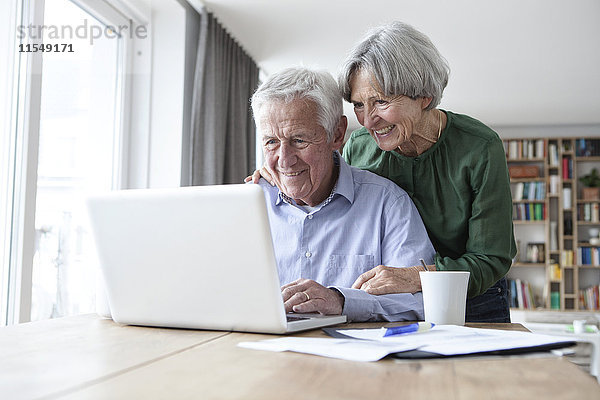 Senior Paar mit Laptop zu Hause