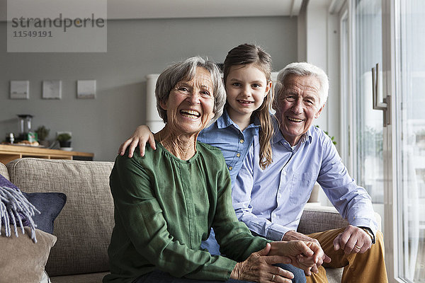 Familienportrait der Großeltern und ihrer Enkelin zu Hause