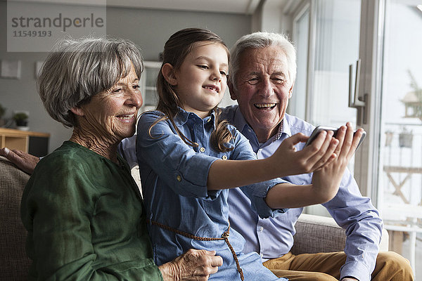 Kleines Mädchen nimmt Selfie mit ihren Großeltern mit nach Hause