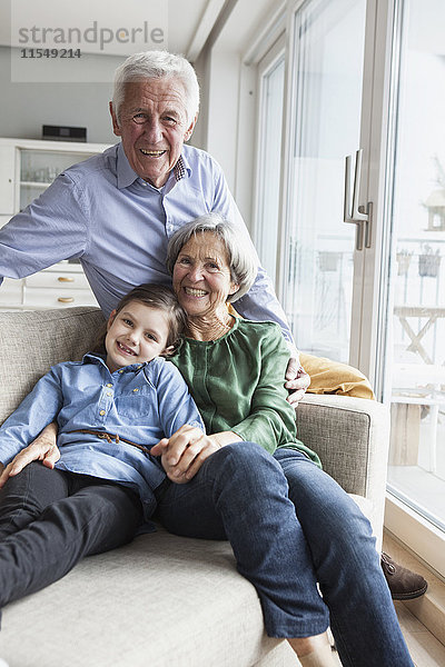 Familienportrait der Großeltern und ihrer Enkelin zu Hause