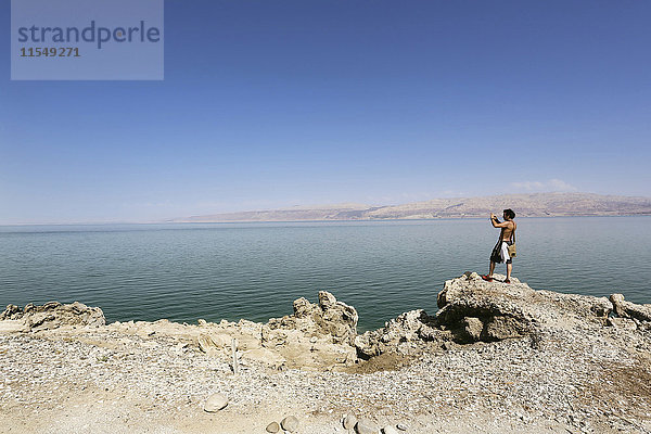Israel  Mann beim Fotografieren am Ufer des Toten Meeres